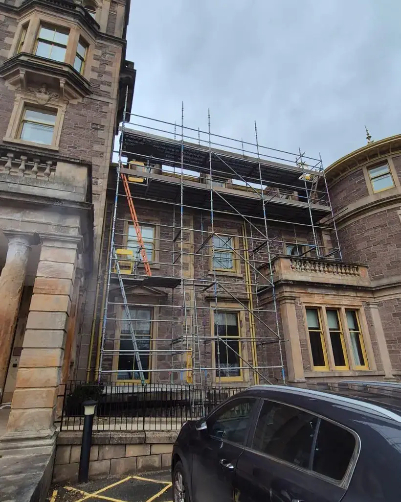 Scaffolding to roof level on an ornate red sandstone building