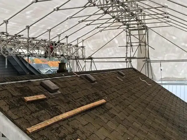 Sheeted temporary roof above a tiled house roof